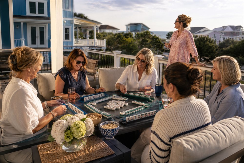 Women playing Mahjong on the deck at golden hour